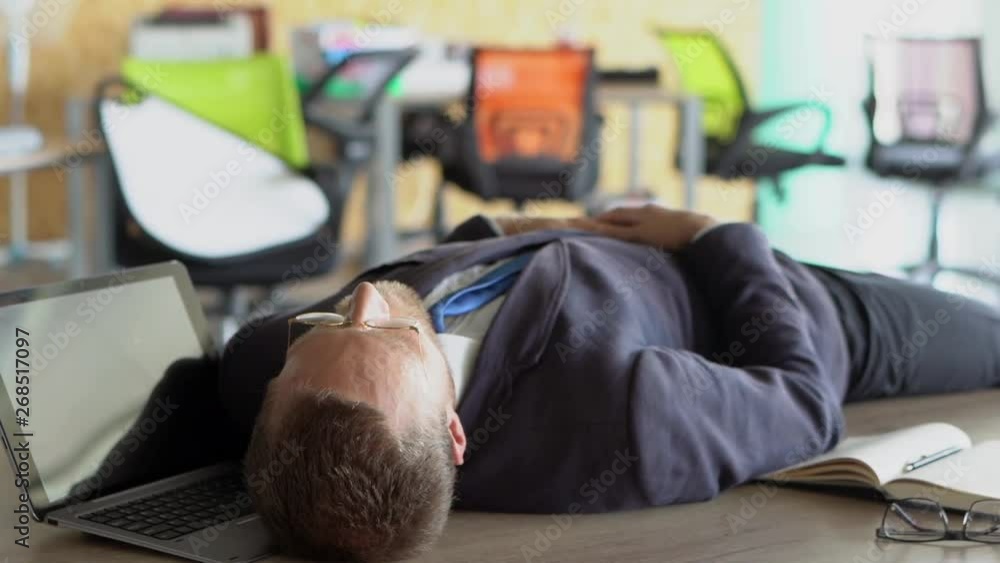 Tired stylish worker is sleeping on table in office Tired stylish worker is sleeping on table in office