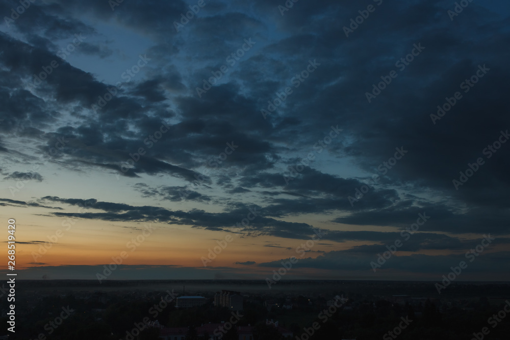 Colorful sunset. Clouds in the evening sky. View from the roof of a multistory building. Ukraine