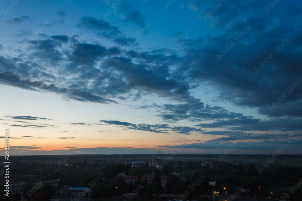 Colorful sunset. Clouds in the evening sky. View from the roof of a multistory building. Ukraine