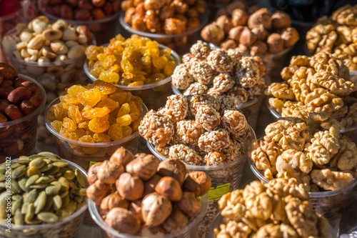 A variety of nuts in plastic bowls in the outdoor market