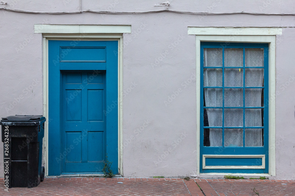 Blue door and window on side of home in urban area Blue door and window on side of home in urban area