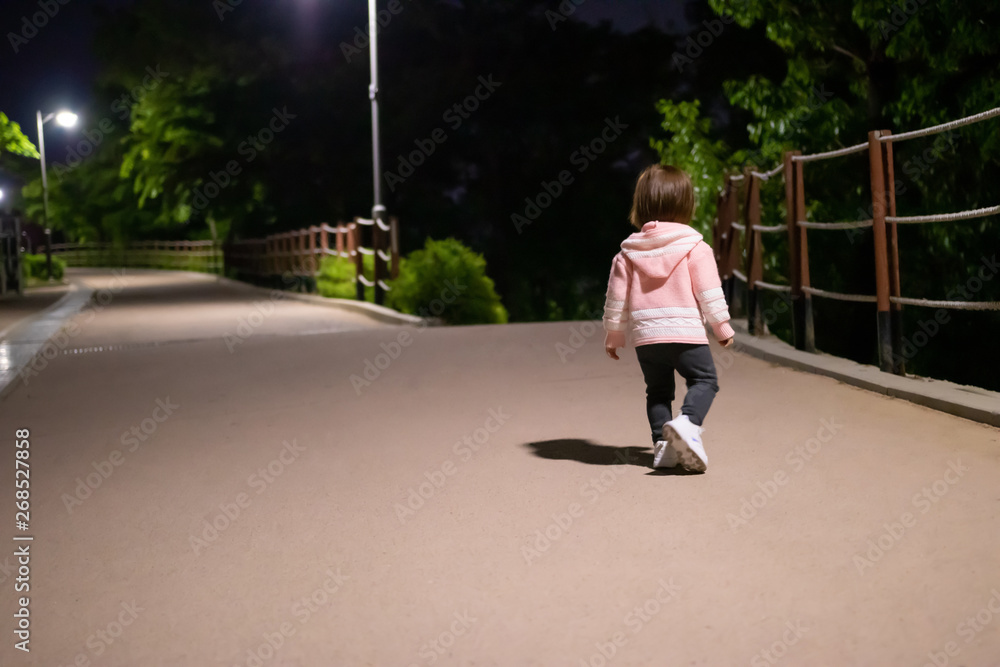 child walks in the park at night child walks in the park at night