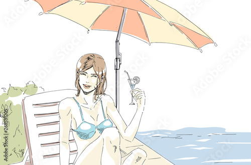 Beautiful elegant girl is relaxing on  chaise lounge on beach and drinking cocktail