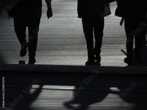 Silhouette of people crossing a bridge