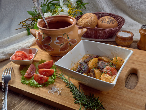 Stewed meat in a ceramic pot with potatoes,champignons,tomatoes and potatoes 