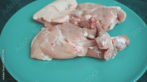 Raw chickhen legs on plate rotating photo