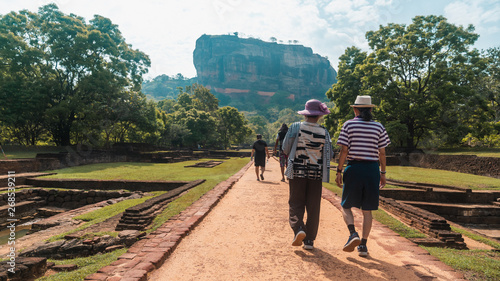 Senior old couple travellers walking up the road to Sigiriya Lion's Rock in Sri Lanka