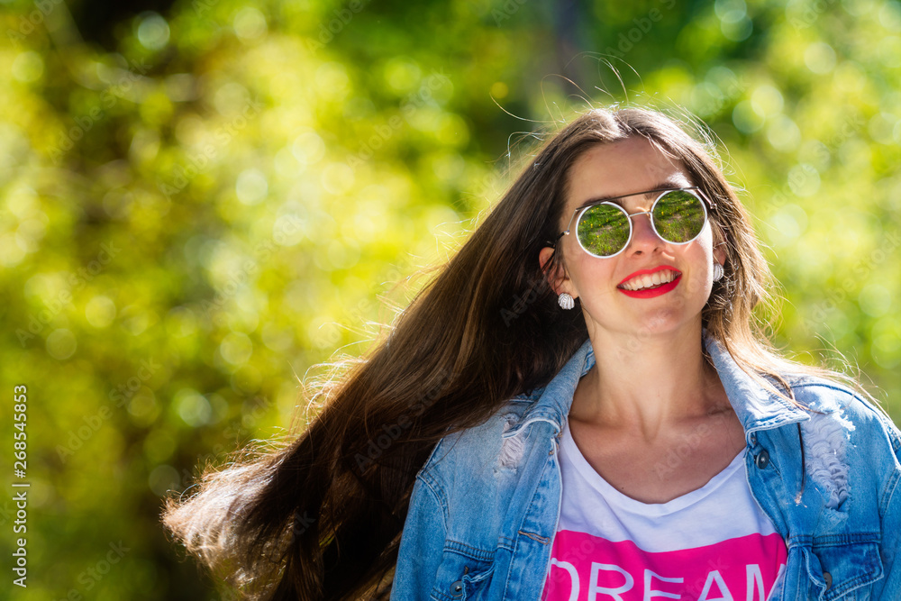 Outdoor portrait of beautiful, emotional, young woman in sunglasses. Soft background. Copy space. Outdoor portrait of beautiful, emotional, young woman in sunglasses. Soft background. Copy space.