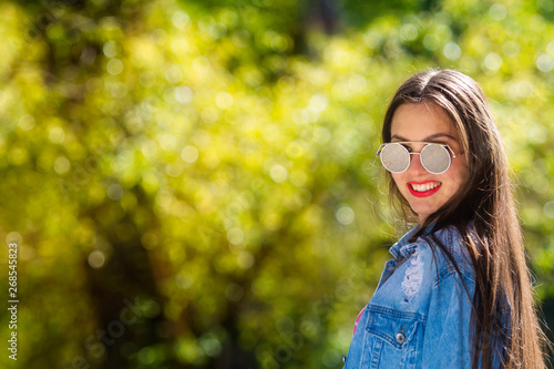 Outdoor portrait of beautiful, emotional, young woman in sunglasses. Soft background. Copy space. © ako-photography