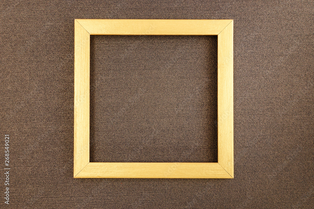 Fototapeta premium Golden square frame on brown mother-of-pearl designer cardboard.