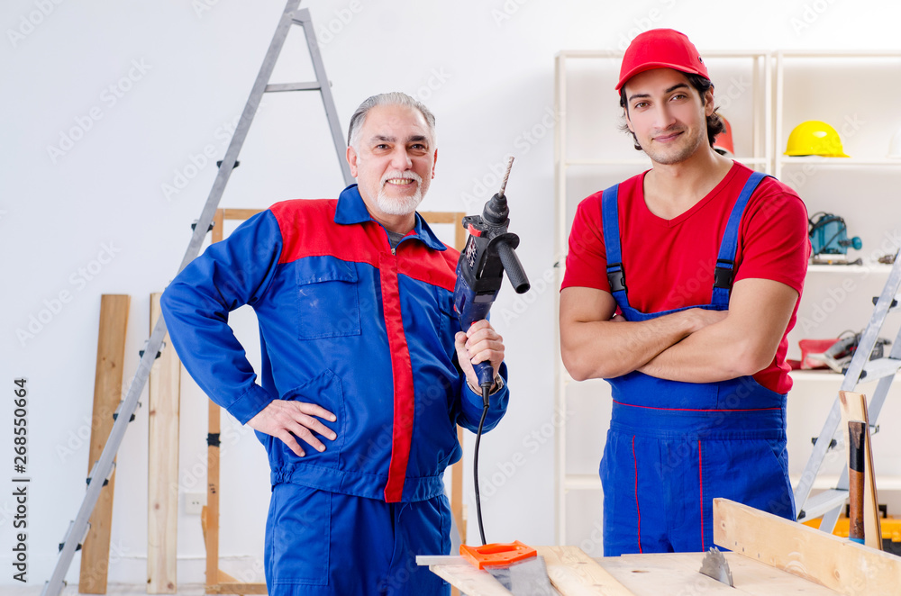 Two professional contractors laying flooring at home Two professional contractors laying flooring at home
