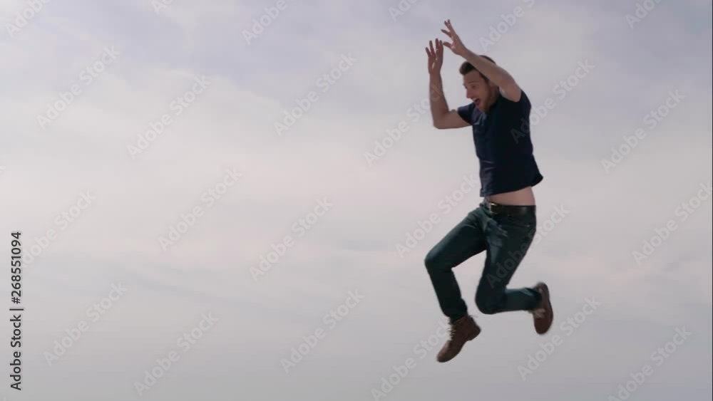 Two fun and happy caucasian adult friends jump with an expression of joy in front of a sky background in slow motion. Two fun and happy caucasian adult friends jump with an expression of joy in front of a sky background in slow motion.