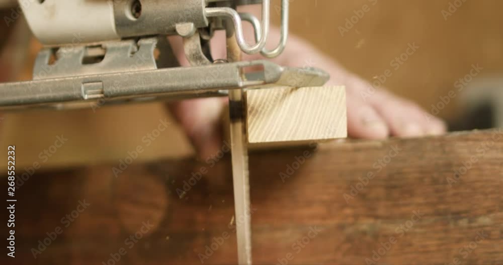 Jig saw begins cutting hard wood, with saw dust flurries in slow motion, at 60 fps. Jig saw begins cutting hard wood, with saw dust flurries in slow motion, at 60 fps.