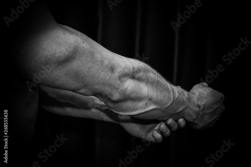 athlete shows pumped hand close-up on a black background. bodybuilding mr. olympia