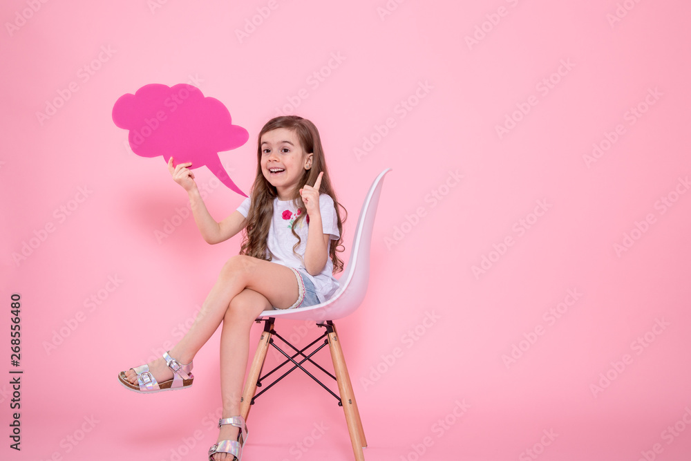 Cute little girl with an icon of a speech on a pink background Cute little girl with an icon of a speech on a pink background