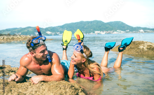 Happy couple of vacationer in love having fun at water on tropical beach in Thailand with snorkel mask and fins - Active youth travel concept around the world - Warm bright day filtered color tones © Mirko Vitali