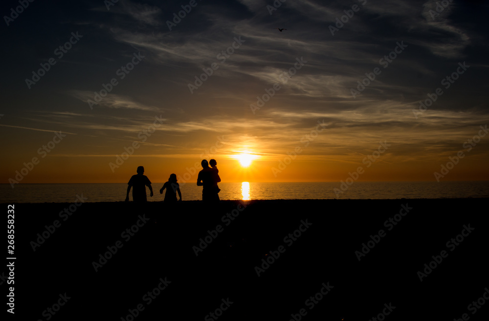 Family walking into sunset on the beach