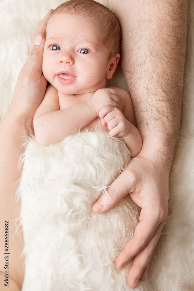 Newborn Baby in Family Hands, Beautiful New Born Kid, Parents Care and Babyhood Concept Newborn Baby in Family Hands, Beautiful New Born Kid, Parents Care and Babyhood Concept