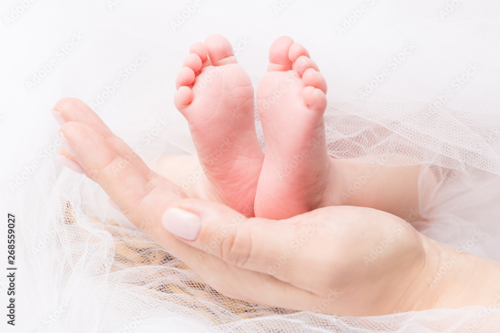 Feet of Newborn Baby, Mother Holding New Born Kid Legs on Hand