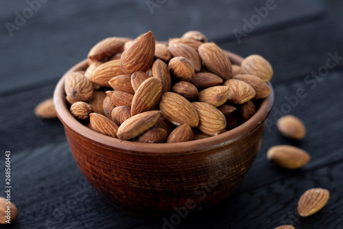 Wallpaper Mural Almonds nuts in ceramic bowl on on the dark oak texture Torontodigital.ca