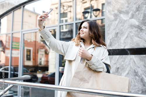 A young, sympathetic woman, not a thin-headed body building, walks around the city with a shopping bag, picks up herself on the phone, and has fun. Shopping and Leisure Free Download A young, sympathetic woman, not a thin-headed body building, walks around the city with a shopping bag, picks up herself on the phone, and has fun. Shopping and Leisure - GFXLoad