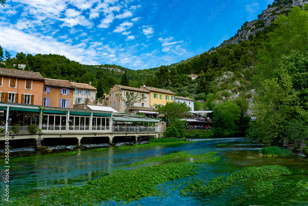 South of France, view on small Provencal town of poet Petrarch Fontaine-de-vaucluse with emerald green waters of Sorgue river