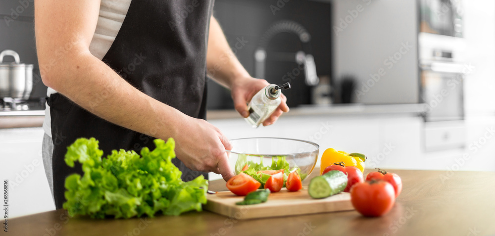 Young trendy man cooking healthy food in the morning