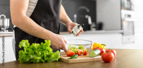 Young trendy man cooking healthy food in the morning