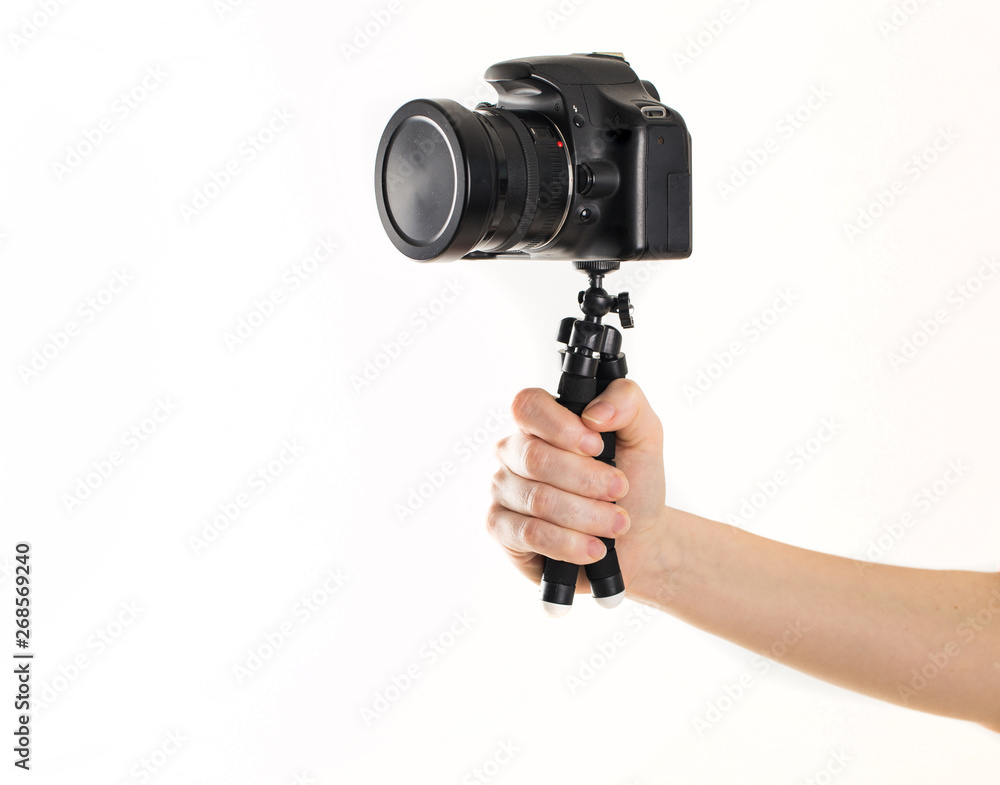 Woman hand and Black DSLR Camera on tripod isolated on white background