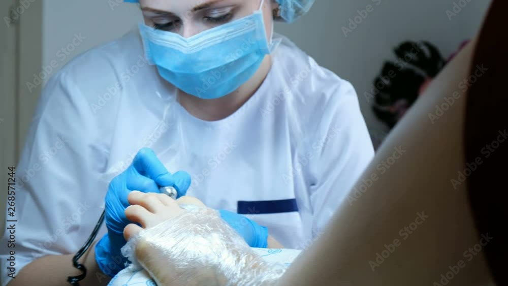 Pedicure master processes removes the cuticle and cuts off the old skin Pedicure master processes removes the cuticle and cuts off the old skin