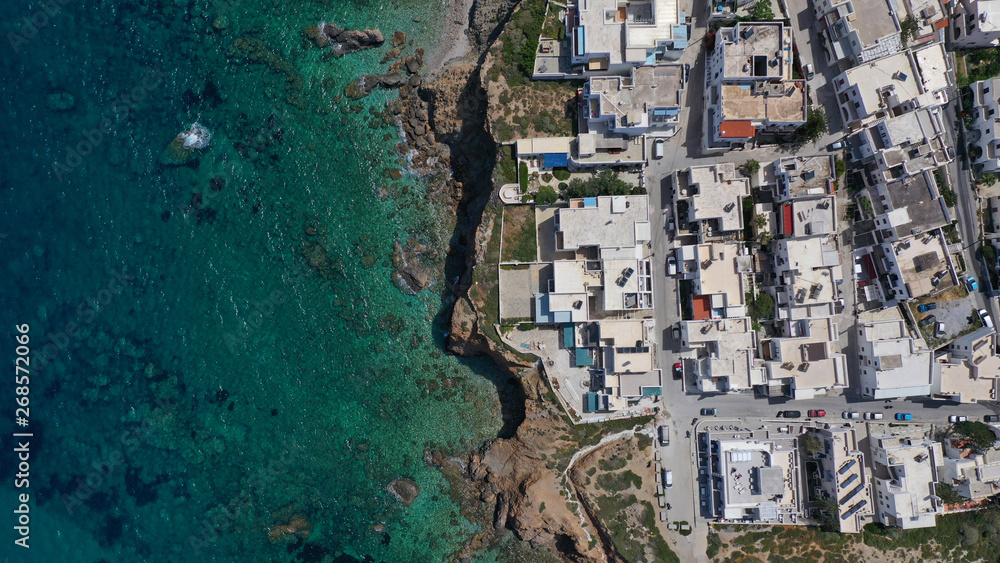 Aerial drone photo of iconic new settlement of Grotta perched on the hill and emerald clear rocky sea below, Naxos island, Cyclades, Greece