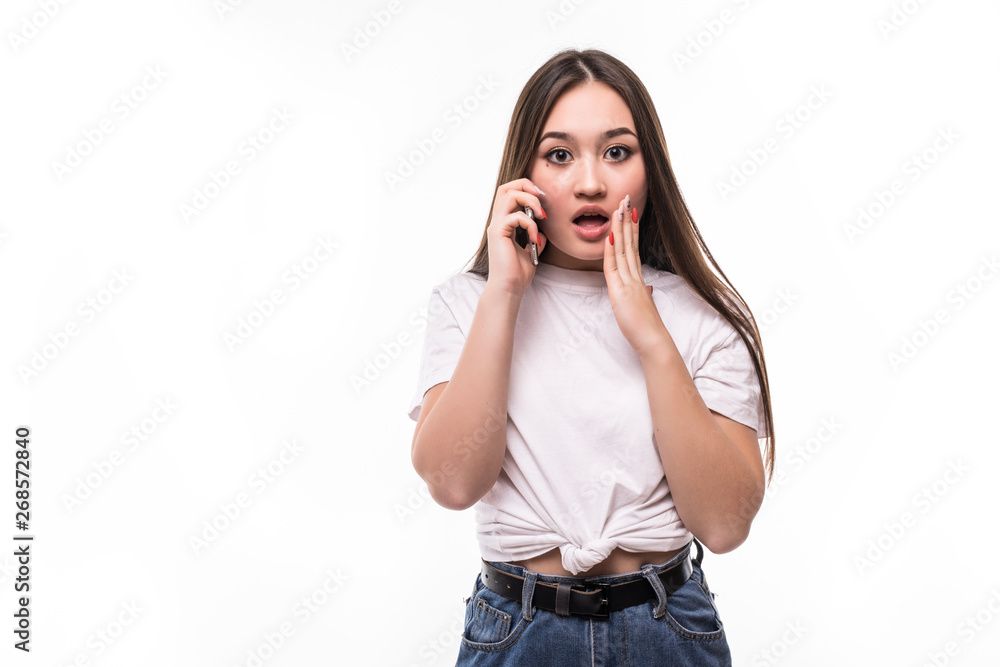 Portrait of an excited shocked asian woman talking on mobile phone and gesturing isolated over white background Portrait of an excited shocked asian woman talking on mobile phone and gesturing isolated over white background