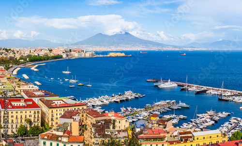 Naples city and port with Mount Vesuvius on the horizon seen from the hills of Posilipo. Seaside landscape of the city harbor and golf on the Tyrrhenian Sea