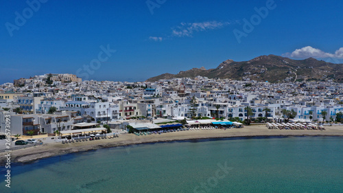 Aerial drone panoramic photo of famous turquoise sea sandy beach of Saint George next to chora main town of Naxos island with beautiful uphill castle, Cyclades, Greece