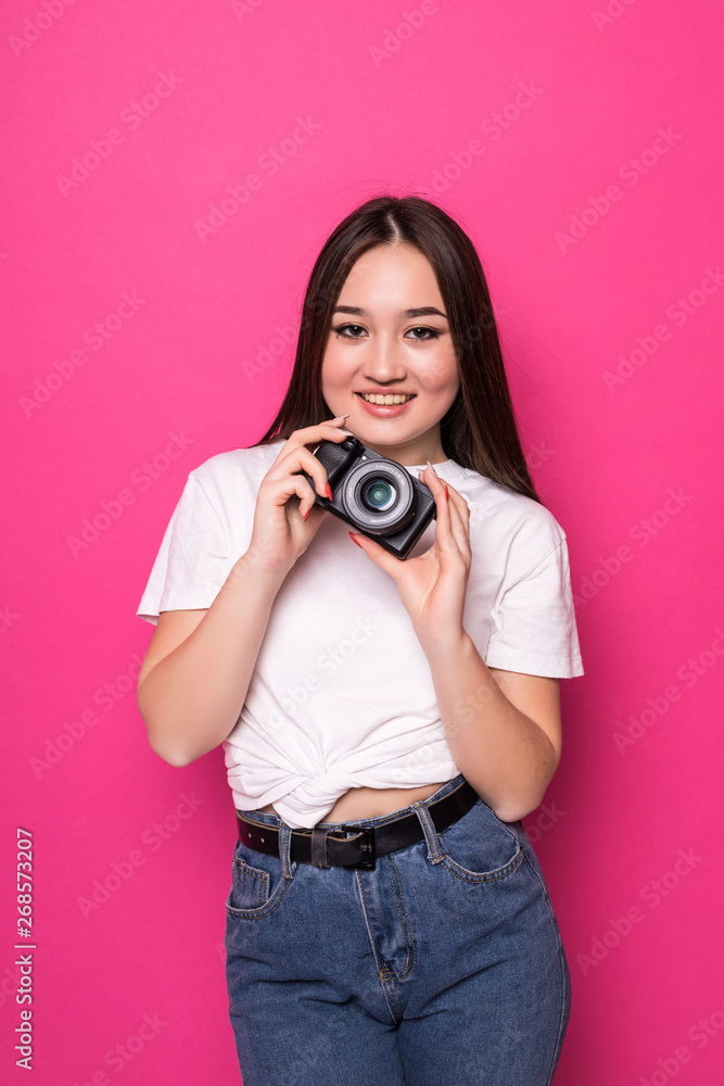 Young pretty asian tourist woman with camera standin isolated on pink background Young pretty asian tourist woman with camera standin isolated on pink background