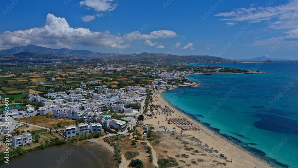 Aerial drone top view photo of breathtaking turquoise sandy beach of Plaka with sun beds and umbrellas, Naxos island, Cyclades, Greece