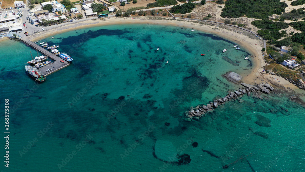 Aerial drone photo of breathtaking turquoise round sandy beach and small village and small seaside picturesque chapel of Agia Anna, Naxos island, Cyclades, Greece