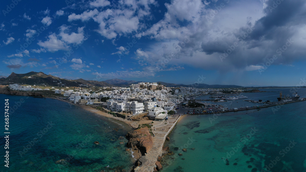 Aerial drone photo of iconic chora, main town of Naxos island featuring beautiful uphill castle views to the Aegean deep blue sea and Temple of Apollon at the background, Cyclades, Greece