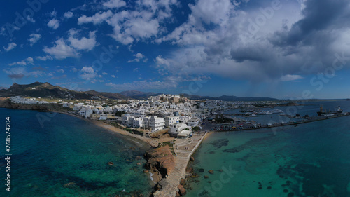 Aerial drone photo of iconic chora, main town of Naxos island featuring beautiful uphill castle views to the Aegean deep blue sea and Temple of Apollon at the background, Cyclades, Greece