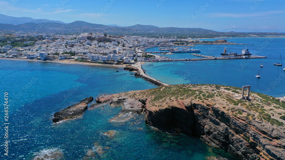 Aerial drone panoramic view of iconic and unique Temple of Apollon or Portara (Gate) with breathtaking views to port - town and castle of Naxos island and the Aegean blue sea, Cyclades, Greece Aerial drone panoramic view of iconic and unique Temple of Apollon or Portara (Gate) with breathtaking views to port - town and castle of Naxos island and the Aegean blue sea, Cyclades, Greece