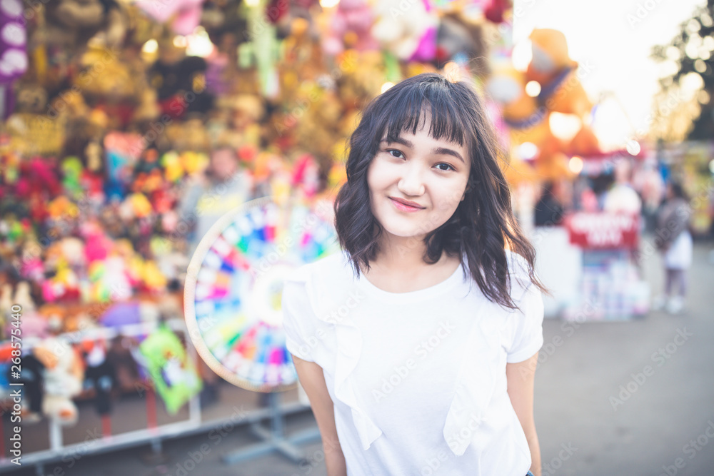 Naklejka premium Beautiful asian girl in an amusement park, smiling