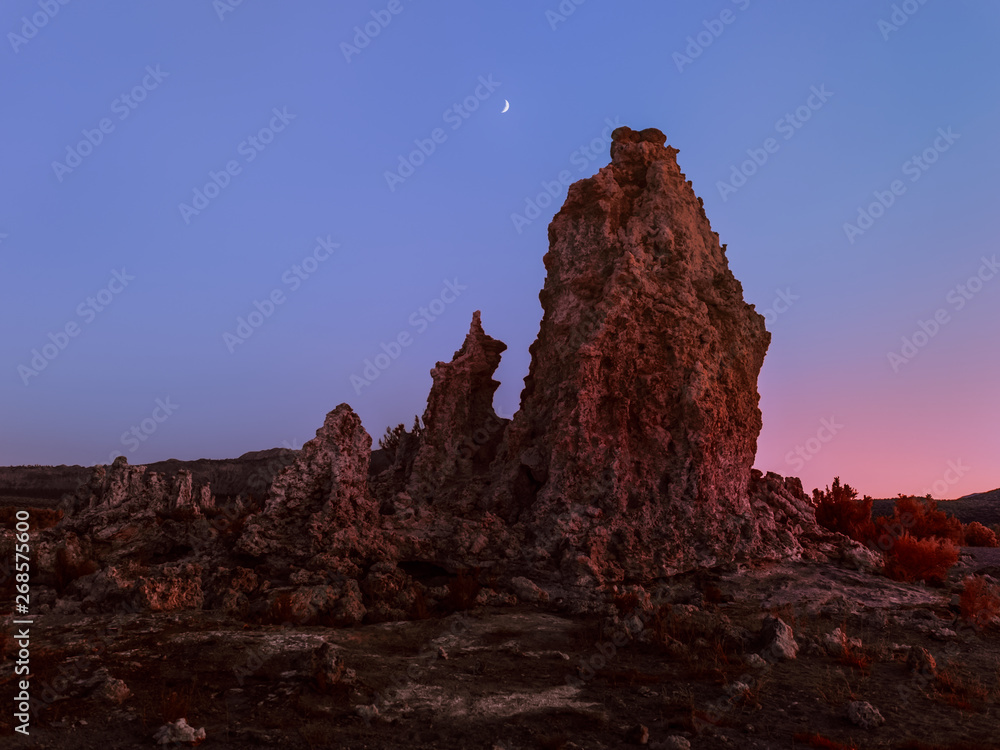 Unearthly scenery with bizarre rock formations and crescent moon
