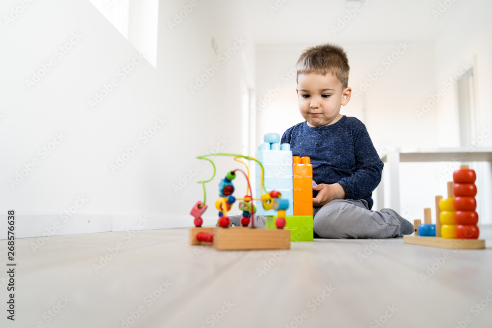 Small boy playing with little brick block toys at home on the floor Small boy playing with little brick block toys at home on the floor