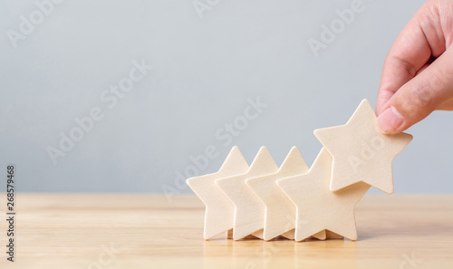 Valokuva Hand putting wooden five star shape on table