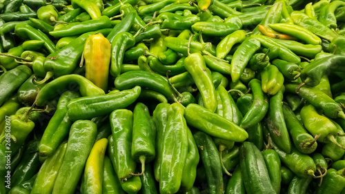 Detail of fresh green California or Anaheim chili peppers. Also called green chiles from the north in Mexico. Grouped on the shelf of a supermarket. photo