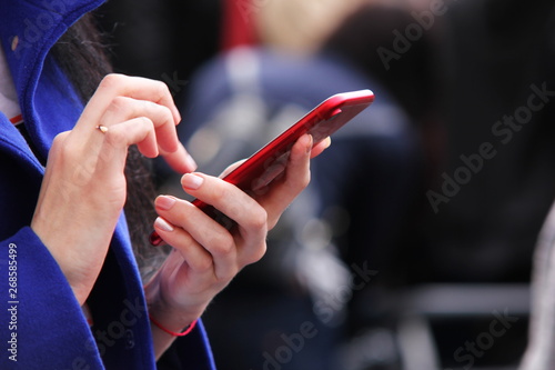Women s hands holding the phone. The use of a touch phone