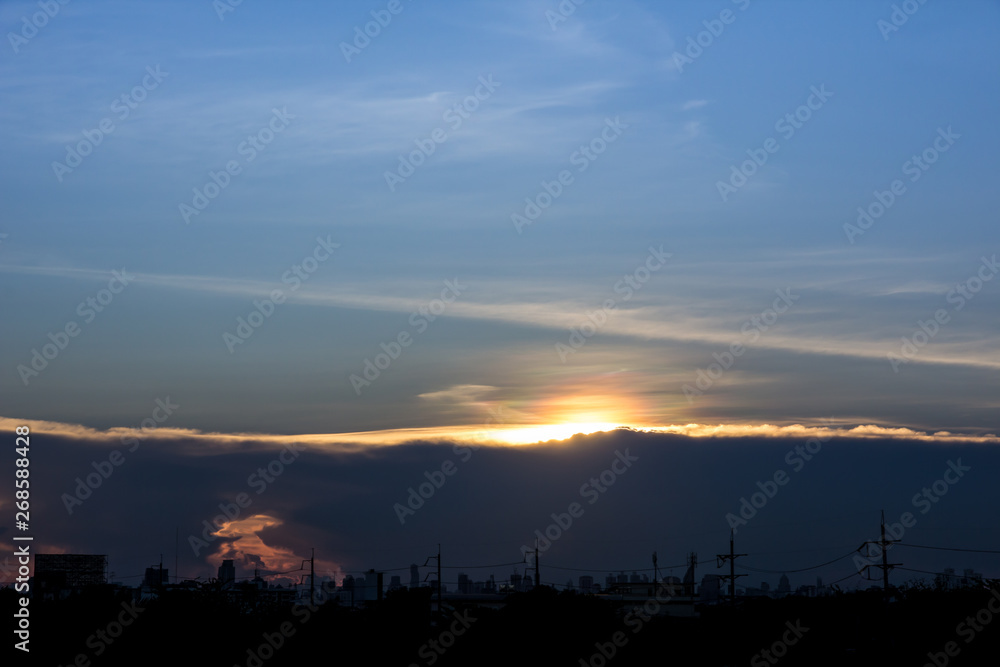 A sunset image with a cloud divides the line between the center of the image with the background