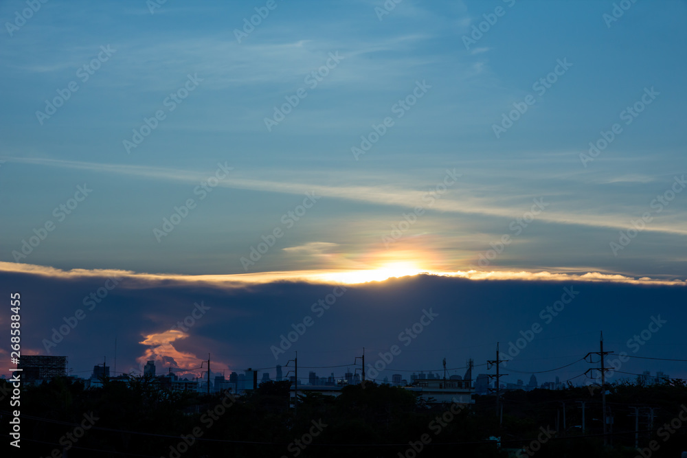 A sunset image with a cloud divides the line between the center of the image with the background