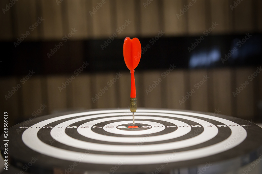 Red dart arrow hitting in the target center of dartboard on bullseye with sun light vintage style, Target marketing and business success concept - Image. Red dart arrow hitting in the target center of dartboard on bullseye with sun light vintage style, Target marketing and business success concept - Image.