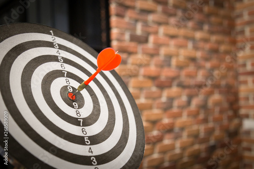 Red dart arrow hitting in the target center of dartboard on bullseye with sun light vintage style, Target marketing and business success concept - Image. photo